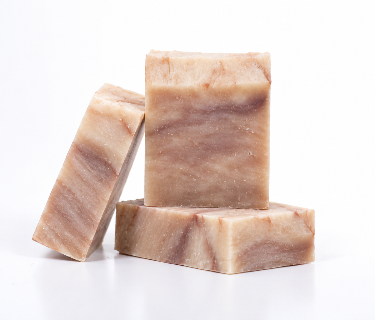 Three rectangular bars of handmade soap with a marbled beige and brown stone-like pattern, arranged on a clean white background. Vanilla and Sandalwood, Organic and Fair Trade, Cold Pressed.
