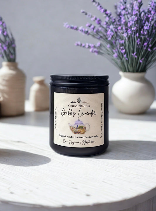 Candle labeled 'Gables Lavender' on a white surface with lavender flowers in the background.