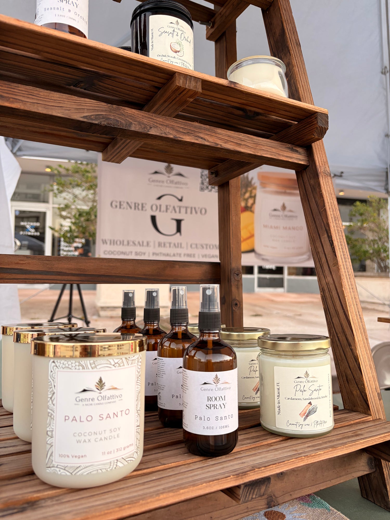 Wooden shelf with candles and bottles on a blurred outdoor background