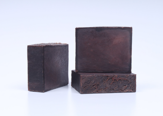 Three bars of dark vanilla soap on a white background