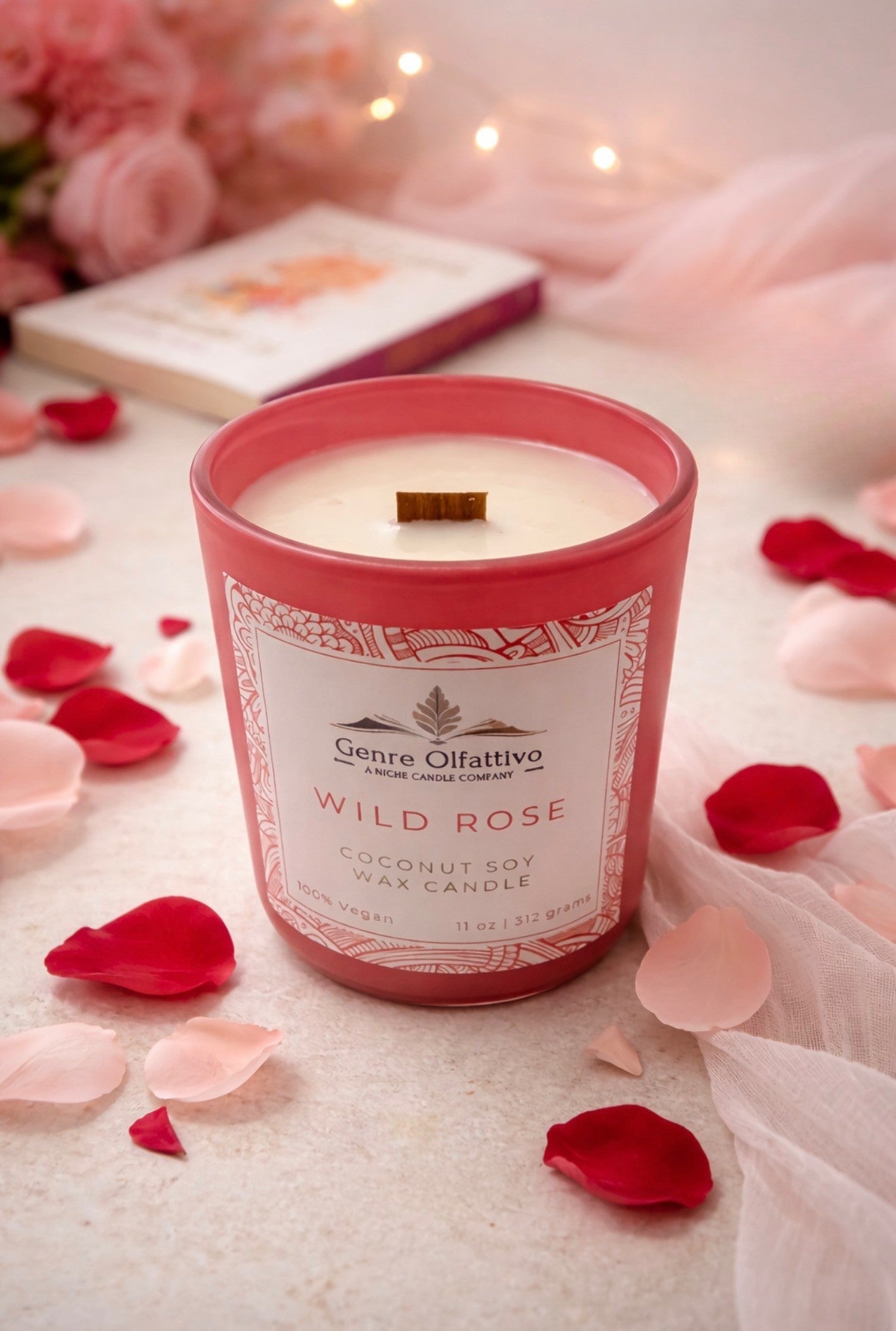 Rose Candle in a pink container with 'Genre Olfattivo' branding, surrounded by rose petals on a soft background.